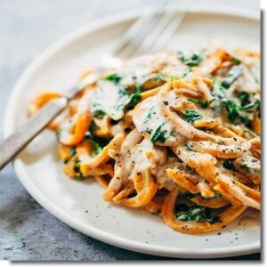 Sweet potato spaghetti, spinach shoots, garlic, soy and hazelnut cream, vegan parmesan